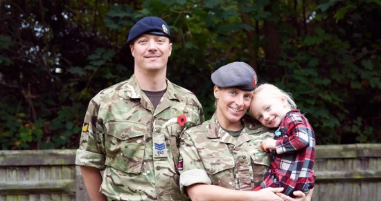 Military couple in camouflage uniforms with small child 